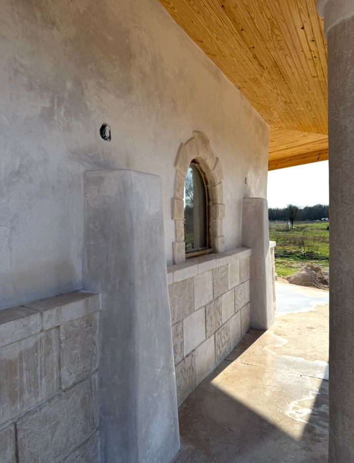 Carved stone arched window on covered porch