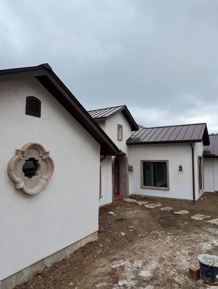 White lime plaster exterior with carved stone quatrefoil window