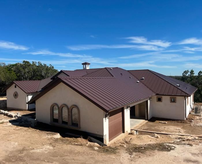 House exterior with standing seam metal roof and arched windows