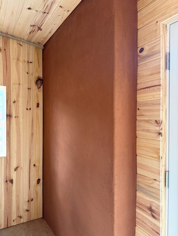 Terracotta clay plaster wall between cedar paneled walls