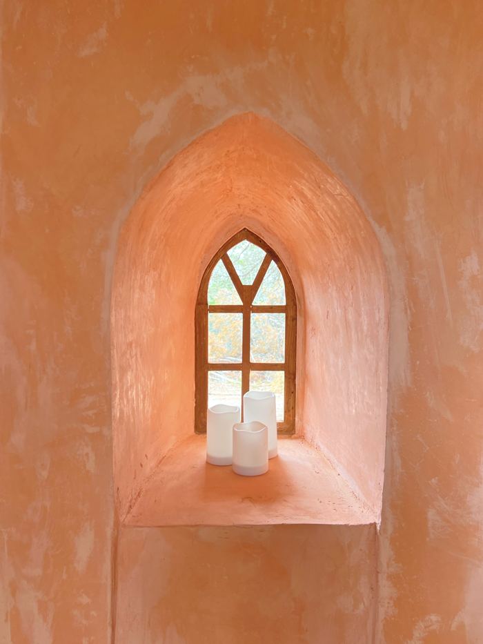 Terracotta plaster arched window nook with candles