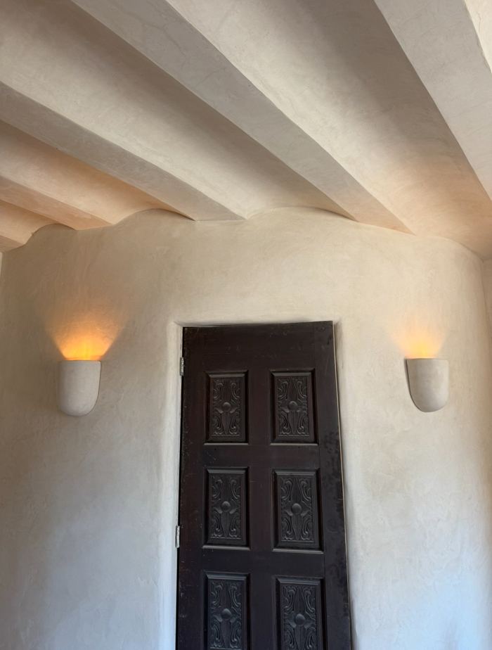 Beamed lime plaster ceiling and carved wood door