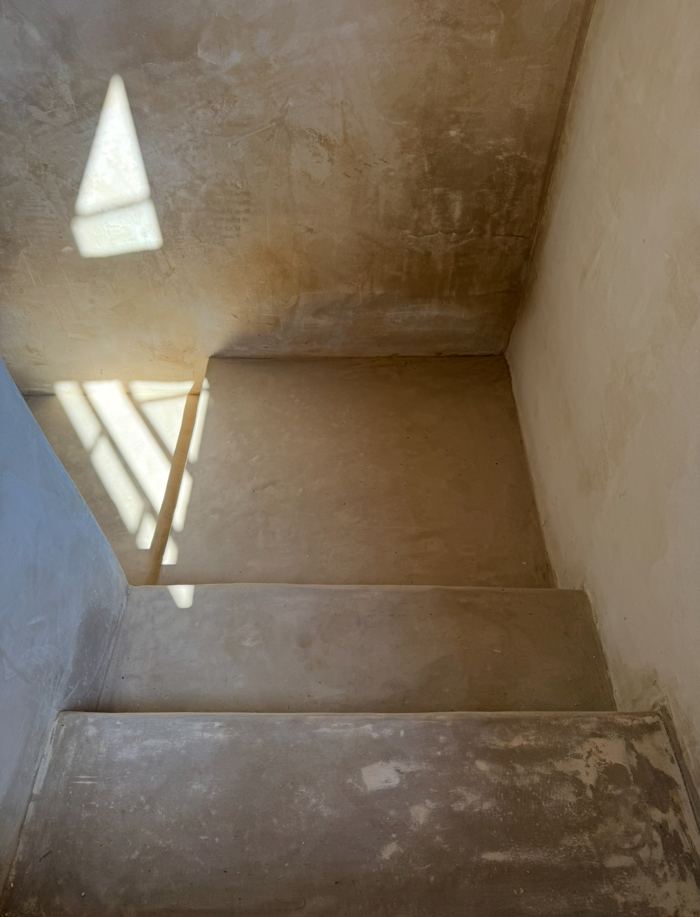 Tadelakt stairwell with light streaming down steps