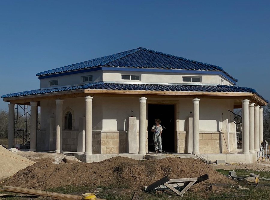 The Adobe Gallery under construction with lime plaster walls and blue tile roof