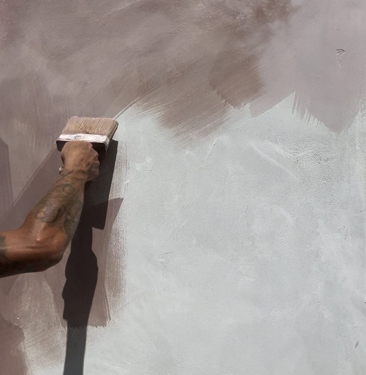 Lime wash being brushed onto a wall, leaving a soft mottled finish