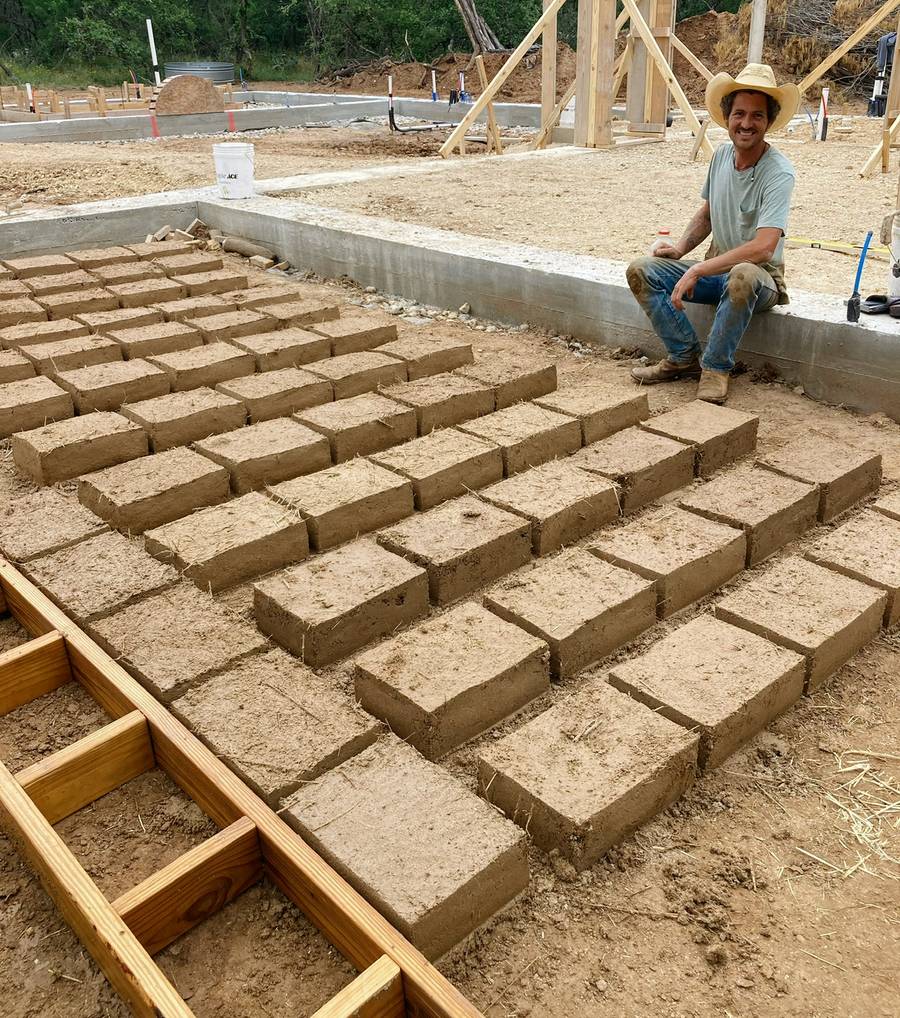 Adobe bricks laid out to cure on a foundation slab