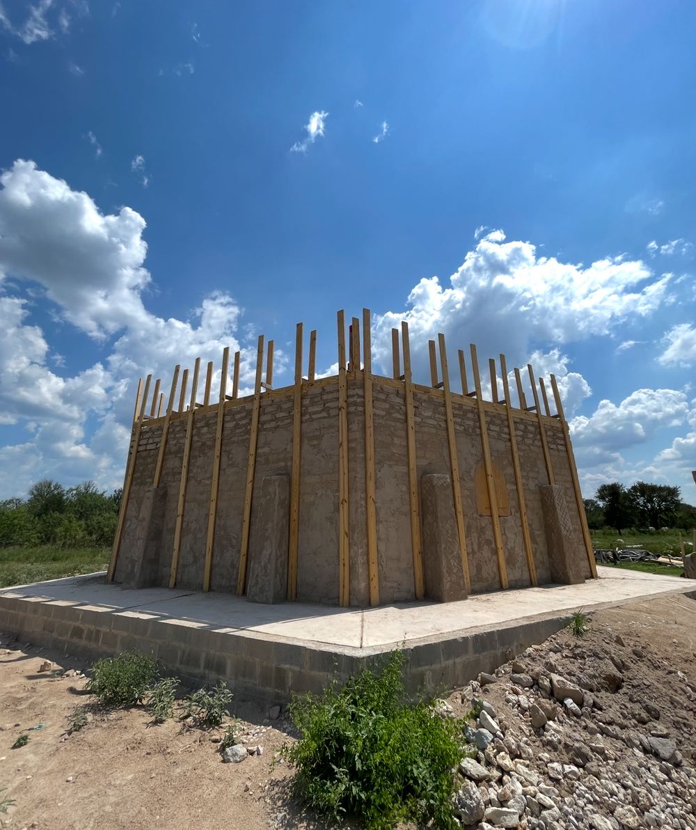 Adobe walls up to plate height with roof framing going on