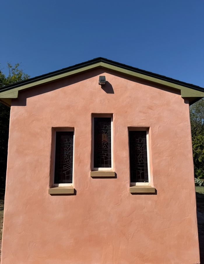 Pink lime plaster gable with stained glass