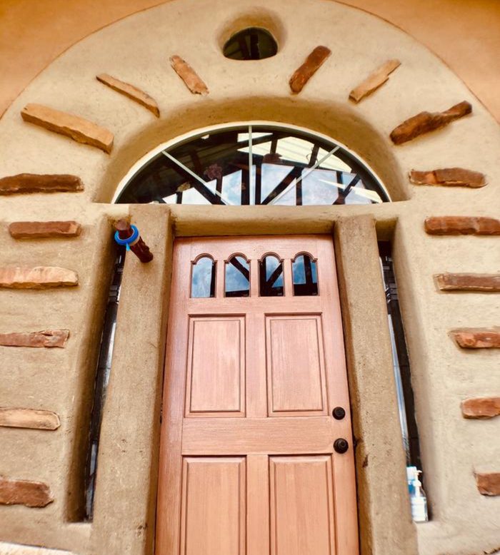 Clay plaster arched entryway with inset stone detail